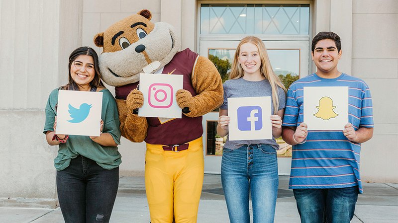 Students with Goldy holding up signs with social media logos