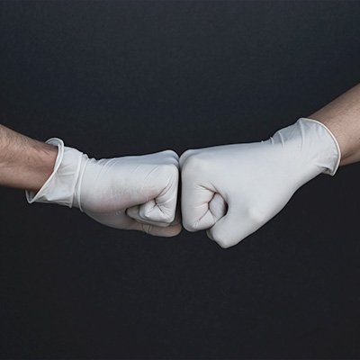 Two gloved hands fist-bumping